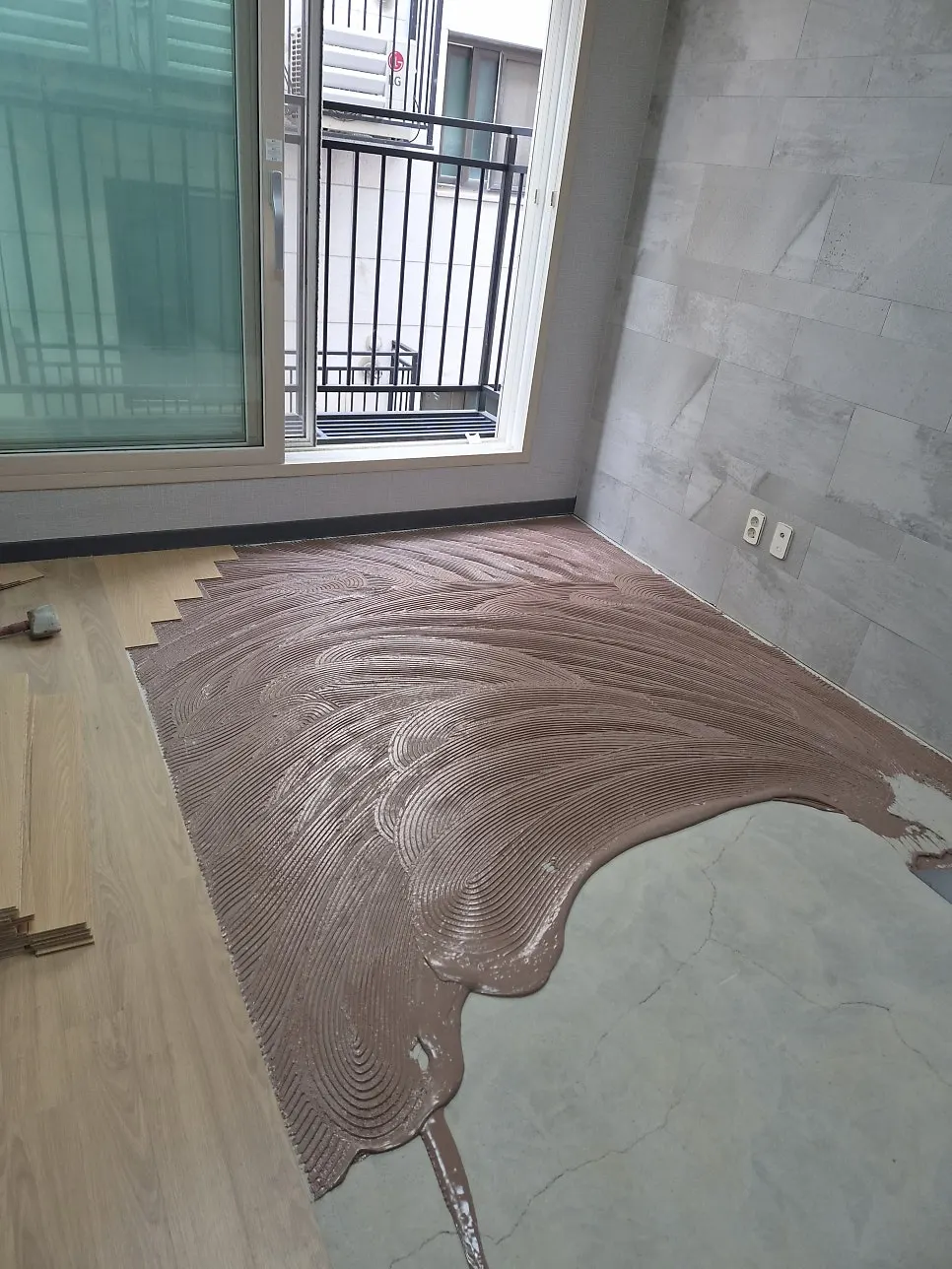 바닥에 마루 전용 본드를 넓게 펴 바른 모습